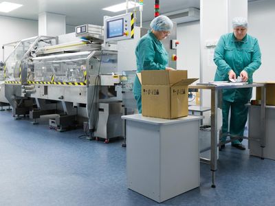 Operadoras en sala limpia empacando productos junto a línea de producción automatizada